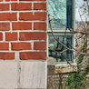 A brick building with a chair reflected in the window of another building.