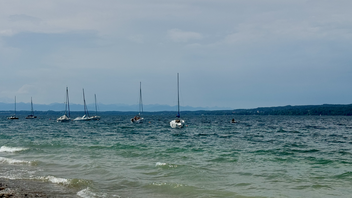 Several boats are in the water and some people are on them.